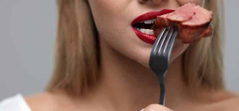 Femme mangeant de la viande